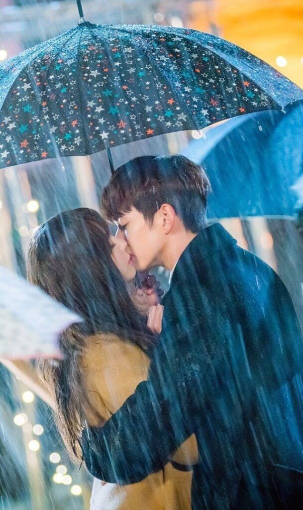 "Couple kissing under an umbrella in the rain for a Romantic Love Story"